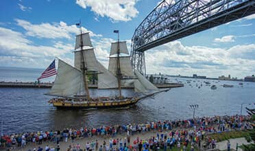 A tall ship sails under Duluth's Aerial Lift Bridge